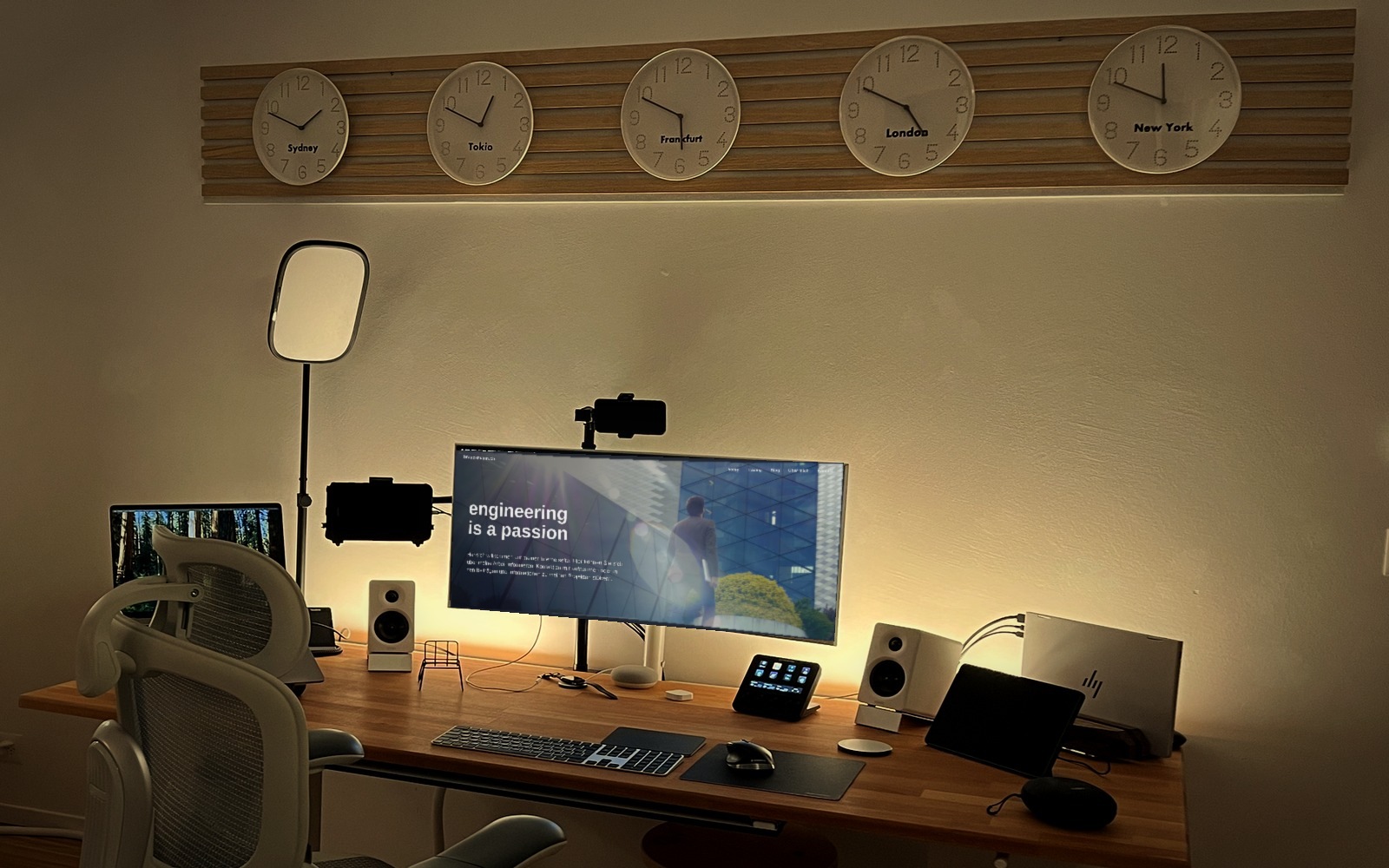 Mein Arbeitsplatz: 34-Zoll-Curved-Monitor in der Mitte, rechts das HP EliteBook, darüber fünf Weltzeituhren
