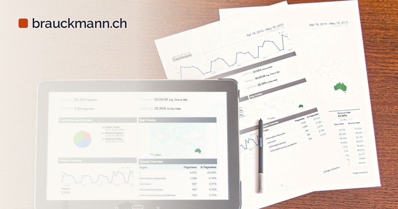 Tablet mit Statistik-Dashboard und ausgedruckte Berichte auf einem Holztisch