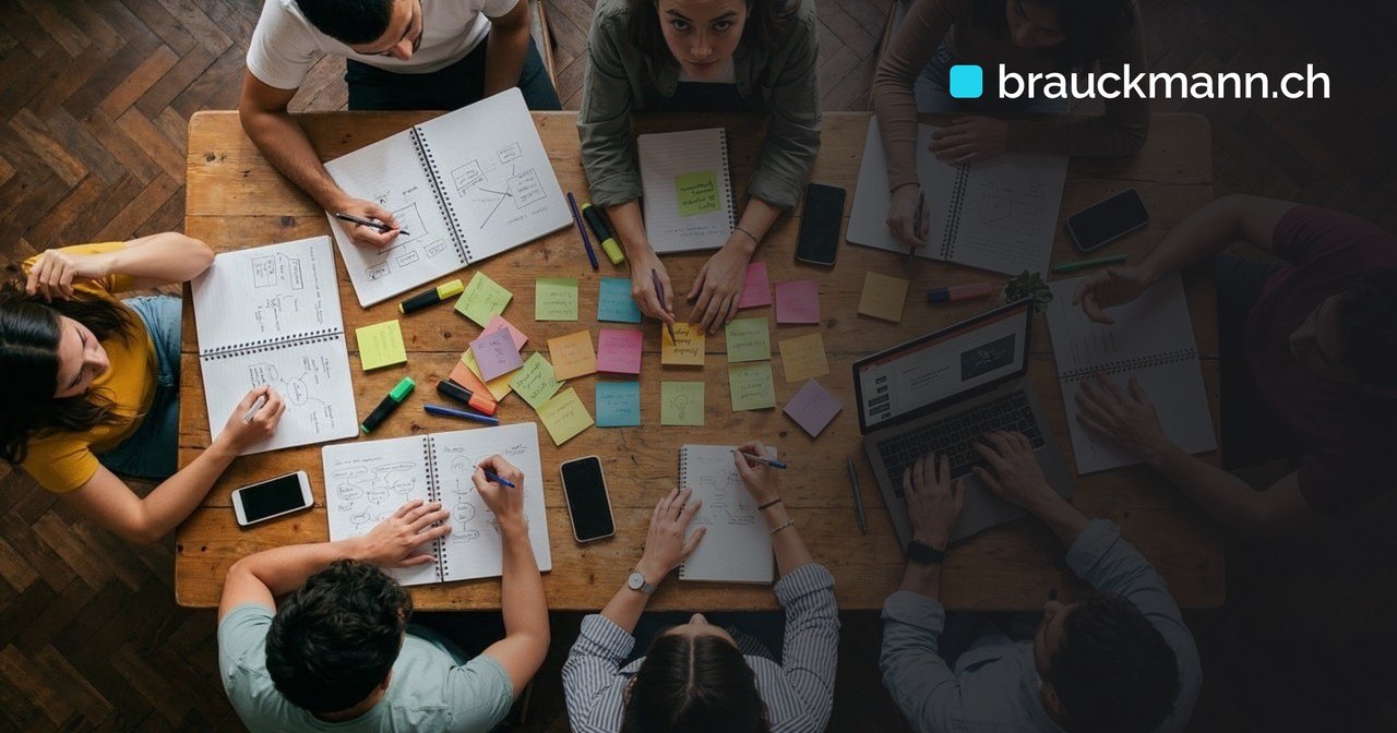 Symbolfoto zum Artikel über Stakeholder im Projektstart: Blick von oben auf ein Team mit Notizbüchern und Haftnotizen an einem Holztisch